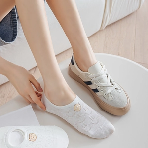Close-up of white invisible socks featuring cute bear and smiley face embroidery details