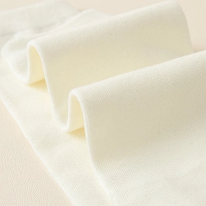 Détail macro du tissu en coton tricoté à fines côtes blanches, texture douce et élastique