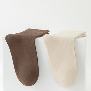 Detail of dark brown and cream mid-calf socks with high-density knit cotton texture