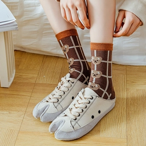 Detailansicht braun karierter Baumwollsocken mit Bärenmotiven und Split-Toe-Turnschuhen