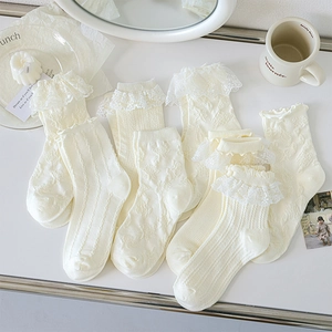 Détail de chaussettes en dentelle blanc crème avec bords à volants et motifs floraux