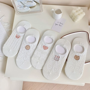Close-up of five white boat socks featuring cute animal and bow embroidery details