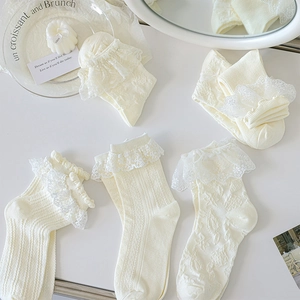 Détail de cinq paires de chaussettes en dentelle beige crème aux textures variées