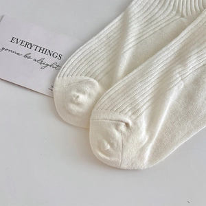 Gros plan de chaussettes en tricot blanc à rayures verticales et pointe sans couture