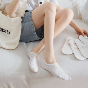 Detail of white mesh no-show socks featuring cute embroidery and anti-slip silicone grip