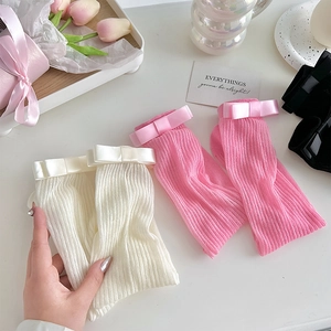 Détail de chaussettes en tricot avec nœuds en soie et texture côtelée de style Lolita