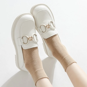 White minimalist loafers with gold metal buckle and camel mid-calf socks for women