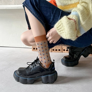 Detail shot of vintage geometric knit socks paired with black platform leather shoes