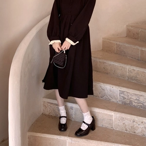 Detail of white lace cuffs on a vintage black long sleeve dress with moon crescent pattern
