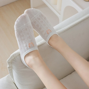 Detail of white mesh boat socks featuring delicate orange floral embroidery for women