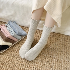 Detail of wool socks showing ribbed texture, lettuce edge trim and soft autumn colors