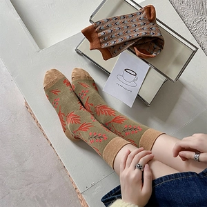 Detail of vintage cotton socks with olive maple leaf and brown geometric patterns