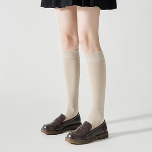 Détail de chaussettes montantes en tricot crème avec revers côtelés et chaussures