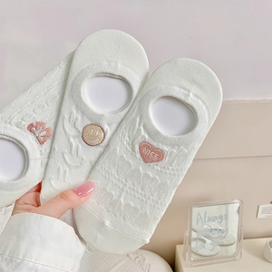 Close-up of white mesh boat socks with cute bow embroidery and silicone non-slip grip