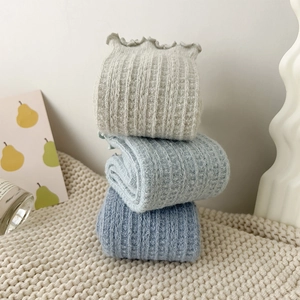 Detail of wool socks with frill edges and vertical knit texture in blue and grey tones