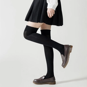 Detail showing high-quality black over-the-knee socks with uniform knit texture and elastic cuff