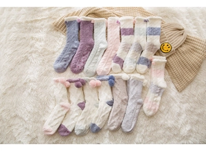 Detailed view of plush coral fleece thermal socks in macaron colors on soft white carpet