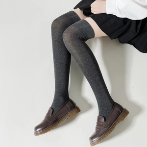 Detail of dark grey over-knee knitted socks with elastic texture for school style