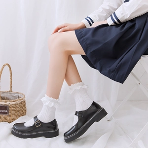 Détail de chaussettes blanches à bordure en dentelle avec chaussures Mary Jane noires style JK