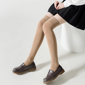 School style khaki over-the-knee high socks paired with black pleated skirt and loafers