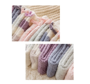Close-up of fluffy coral fleece socks in pastel colors with sweet bow knot details