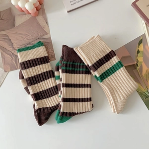 Three pairs of striped crew socks in beige, brown, and green with a ribbed knit texture