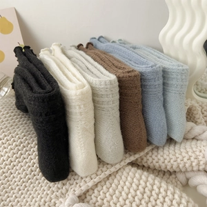 Detail view of colorful wool socks with ruffled edges and thick ribbed knit texture