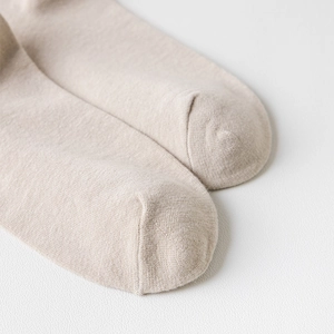 Gros plan sur la pointe des chaussettes beiges montrant la texture fine du tricot