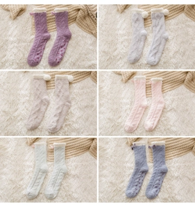 Detail of fuzzy coral fleece socks with anti-slip heart grips and plush pom-poms