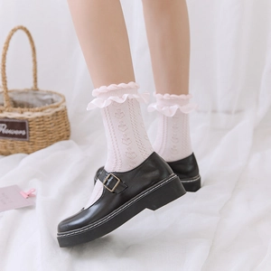 Détail de chaussettes roses à volants JK avec motif cœur et chaussures Mary Jane noires