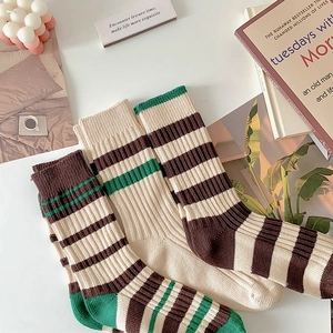 Detailed texture of ribbed knit mid-calf socks with vintage earth-tone stripes