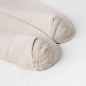 Close-up of the reinforced toe seam on beige knitted over-the-knee socks for women
