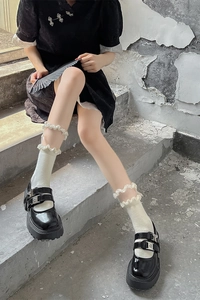 Détail de chaussures Mary Jane en cuir verni noir avec des chaussettes blanches à volants