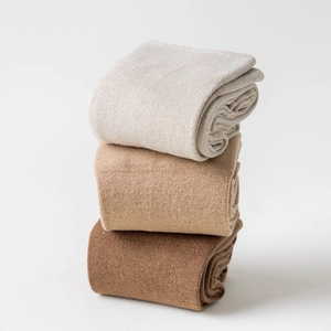 Detailed knit texture of three pairs of knee high socks in earth tones