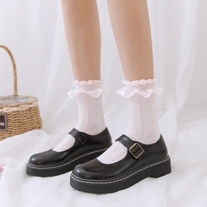 Détail de chaussettes à froufrous en dentelle blanche et chaussures Mary Jane noires Lolita