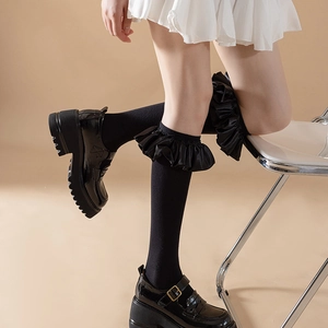 Detail of black Lolita calf socks with ruffled lace edges and chunky Mary Jane shoes