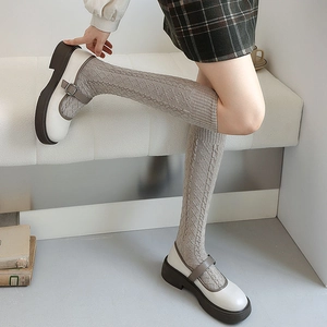 Detail of grey cable knit knee-high socks with retro Japanese preppy style aesthetics