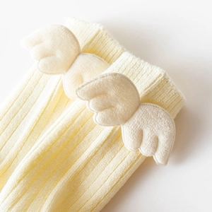 Close-up of ribbed knit socks featuring cute 3D plush angel wings on the cuff edge