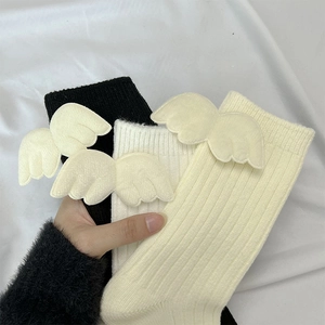 Detailed knit texture of ribbed socks with soft plush angel wings in black and beige