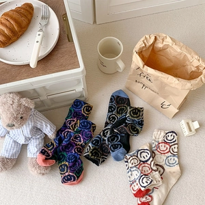 Detailed close-up of colorful smiley face cotton socks in rainbow and blue colorways