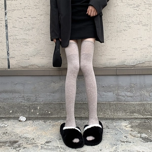 Détail de chaussettes hautes taupe en maille avec revers côtelés et coupe ajustée
