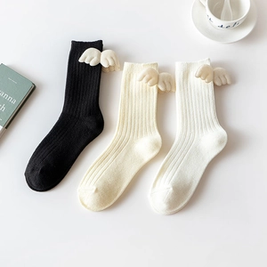 Three pairs of vertical ribbed crew socks with 3D angel wings in black, white, and cream