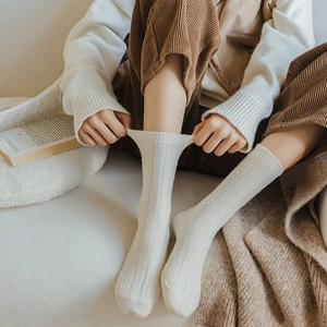 Detailed view of elastic ribbed knit wool socks in cream color for winter warmth