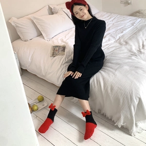 Detail of coral fleece stockings with red 3D bow design and festive indoor style