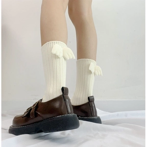 Vertical striped white crew socks with wing accents paired with vintage brown buckled shoes