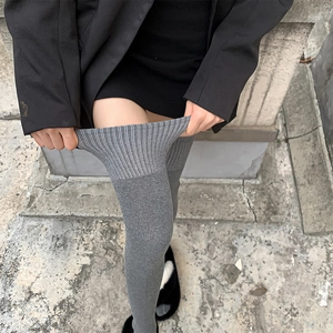 Gros plan de chaussettes hautes grises montrant l'élasticité du bord côte large