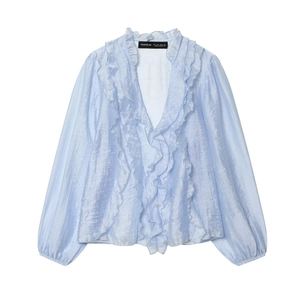 Macro detail of ruffled V-neckline and light blue satin texture on long sleeve chiffon blouse