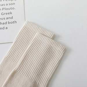 Gros plan détaillé des poignets en tricot blanc crème sur des chaussettes hautes d'hiver