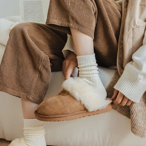 Classic brown suede slippers with thick wool lining shown with corduroy pants