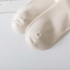 Vue macro des chaussettes montantes en coton avec couture fine et texture crème douce